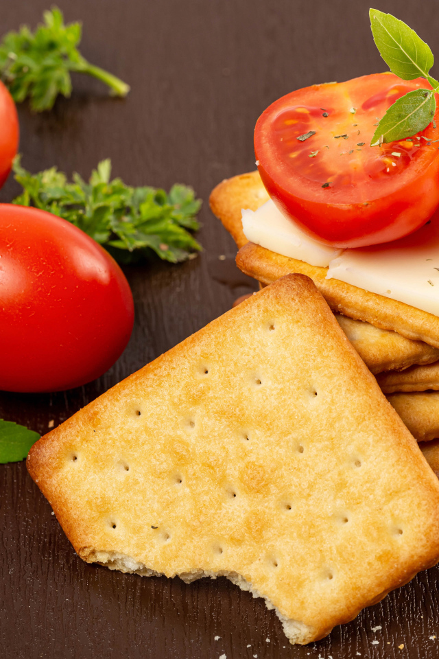 Печенье к крекер с помидорами на столе 