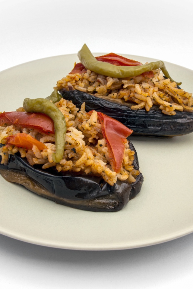 Блюдо из баклажанов с рисом на большой белой тарелке