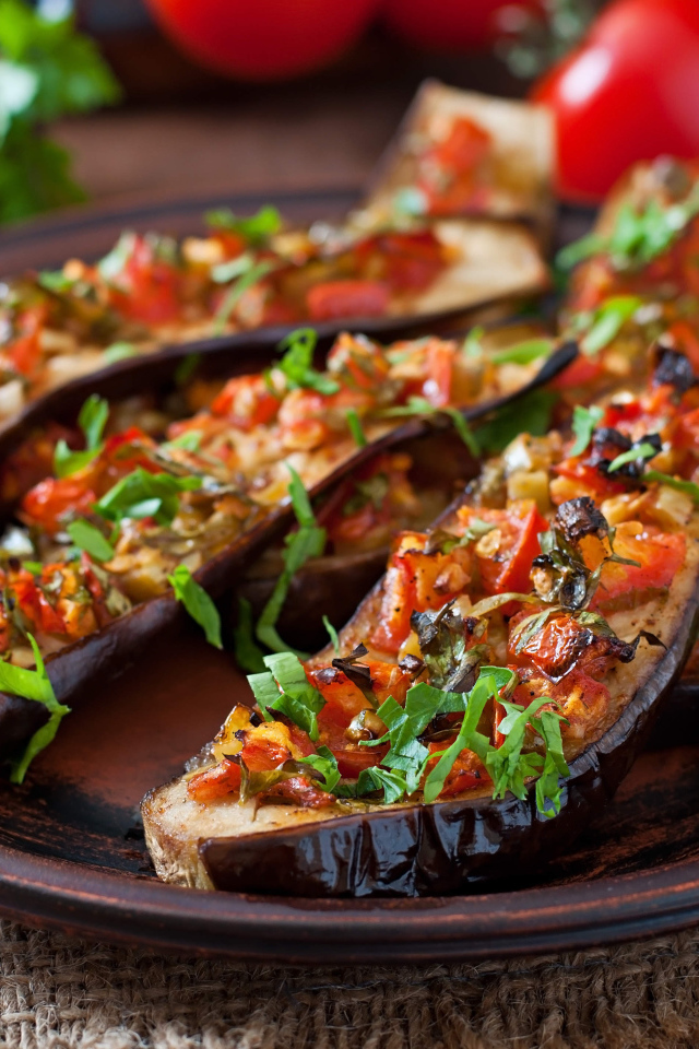 Баклажаны начиненные овощами на тарелке 