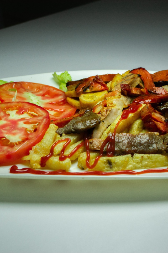 Картофель фри на тарелке с помидорами 