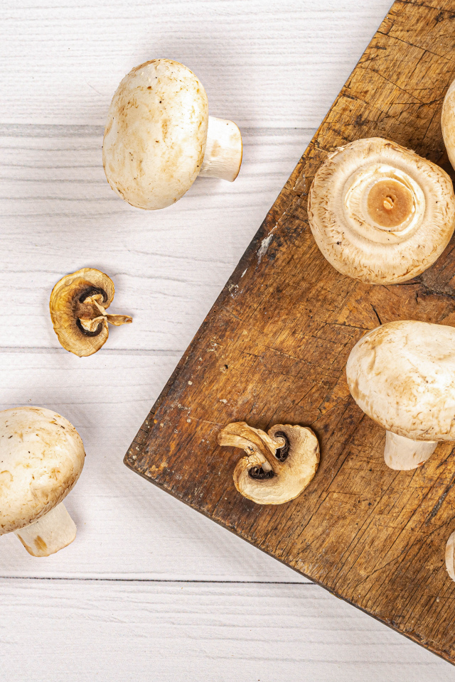 Свежие шампиньоны на разделочной доске