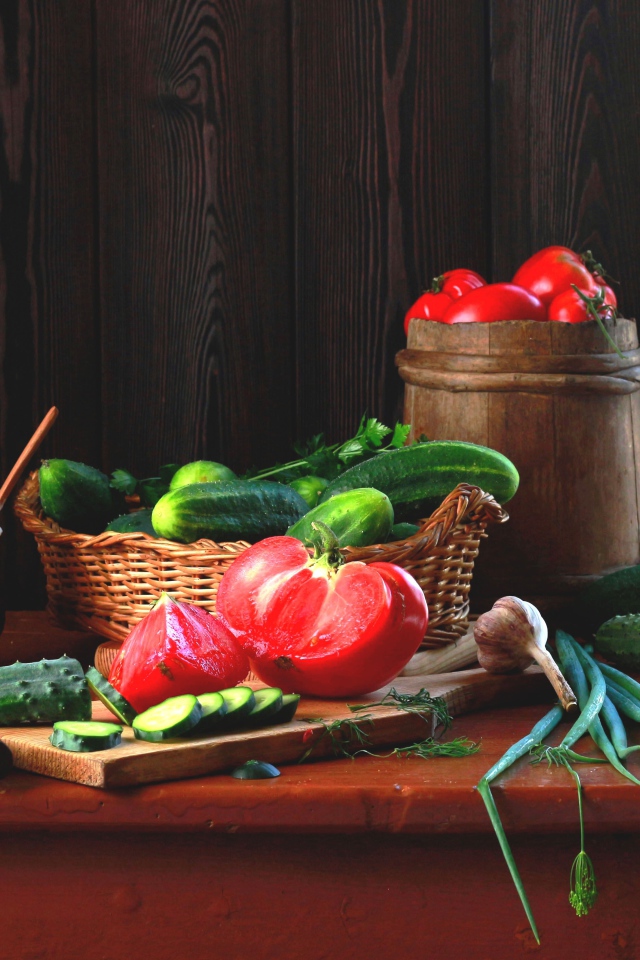 Свежие огурцы и помидора на столе с зеленым луком