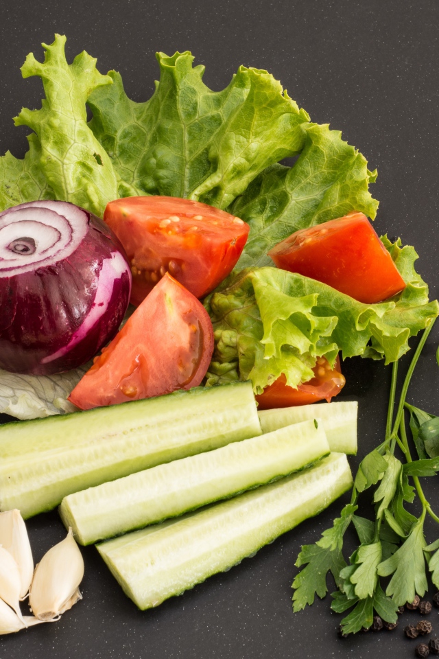 Свежие помидоры, огурцы, лук и листья салата 