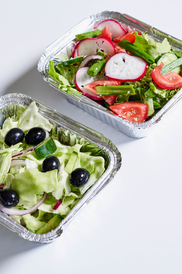 Салат из свежих овощей в тарелках на сером фоне 