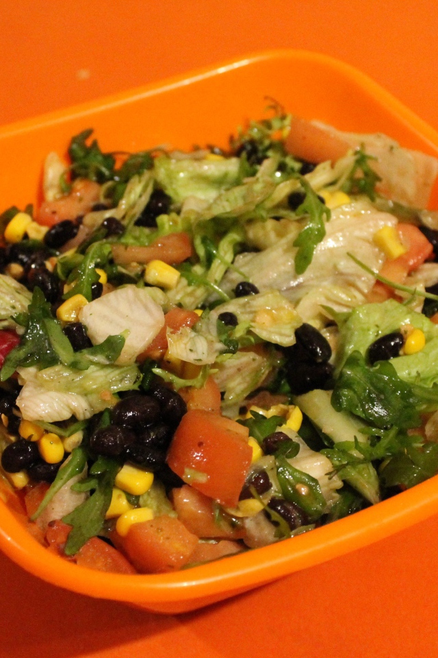 Салат из свежих овощей на оранжевом фоне