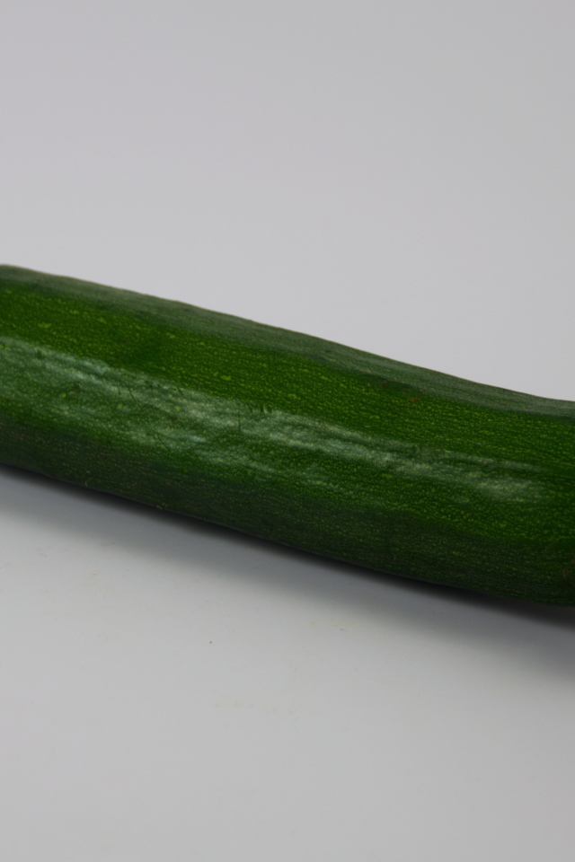 Зеленый кабачок на сером фоне