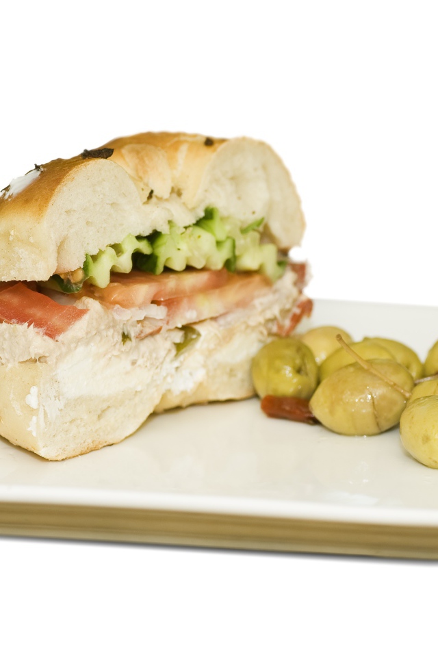 Половина гамбургера на тарелке с оливками