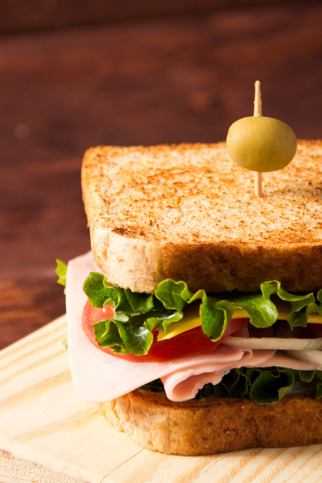 Гамбургер с ветчиной, помидорами, листьями салата и сыром