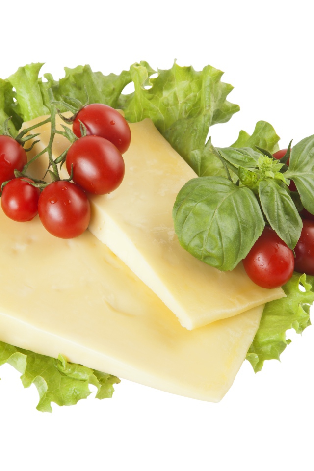Твердый сыр, листья салата, помидоры и базилик на белом фоне