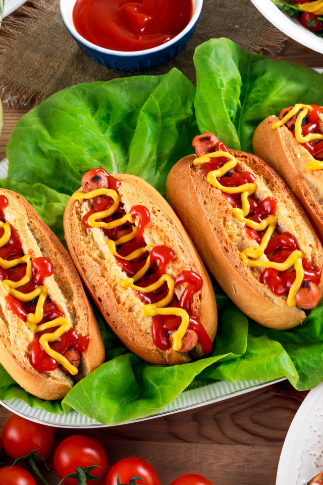 Хотдоги, пицца, лимонад и салат на столе