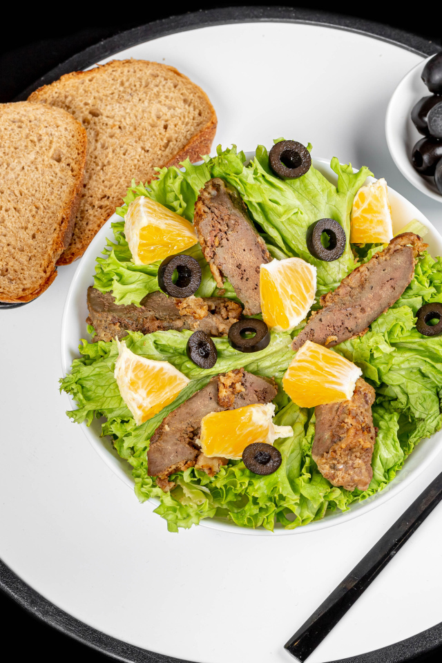 Листья салата с мясом на столе с хлебом