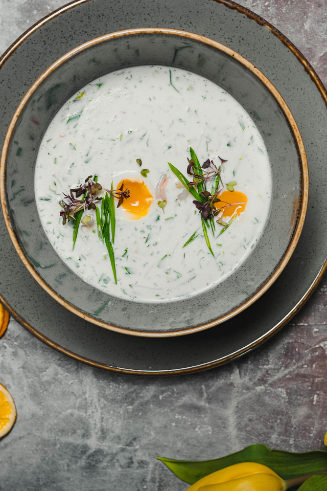 Окрошка на столе с лимонами и тюльпаном