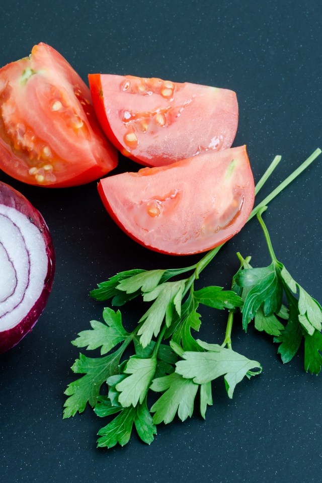 Лук, помидоры и петрушка на сером столе