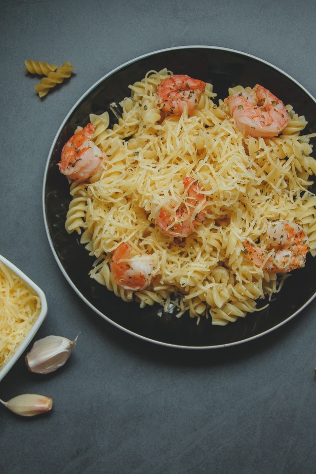Макароны на тарелке с сыром и креветками