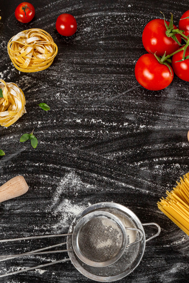 Паста с помидорами и яйцами на черном столе 