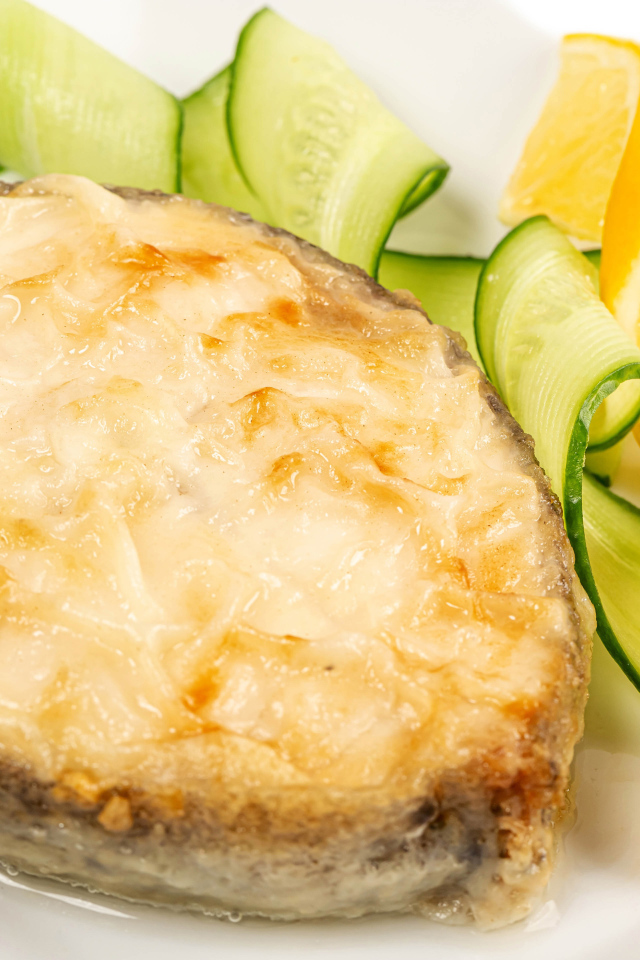 Картофель с сыром на тарелке с огурцами и лимоном 