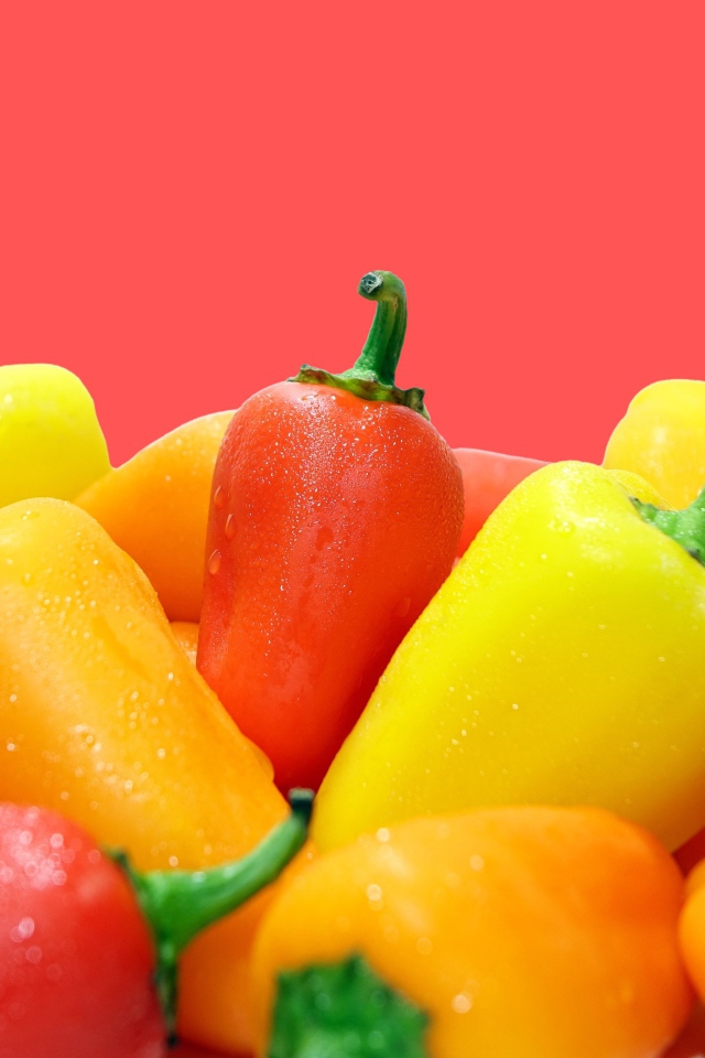 Красный и желтый перец на розовом фоне 