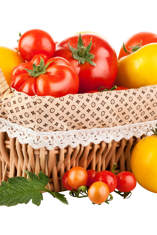 Красные и желтые помидоры в корзине на белом фоне