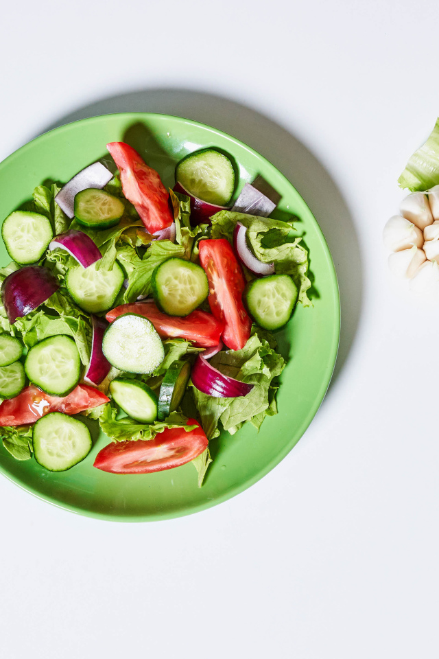 Салат с огурцами, луком, помидорами и листьями салата