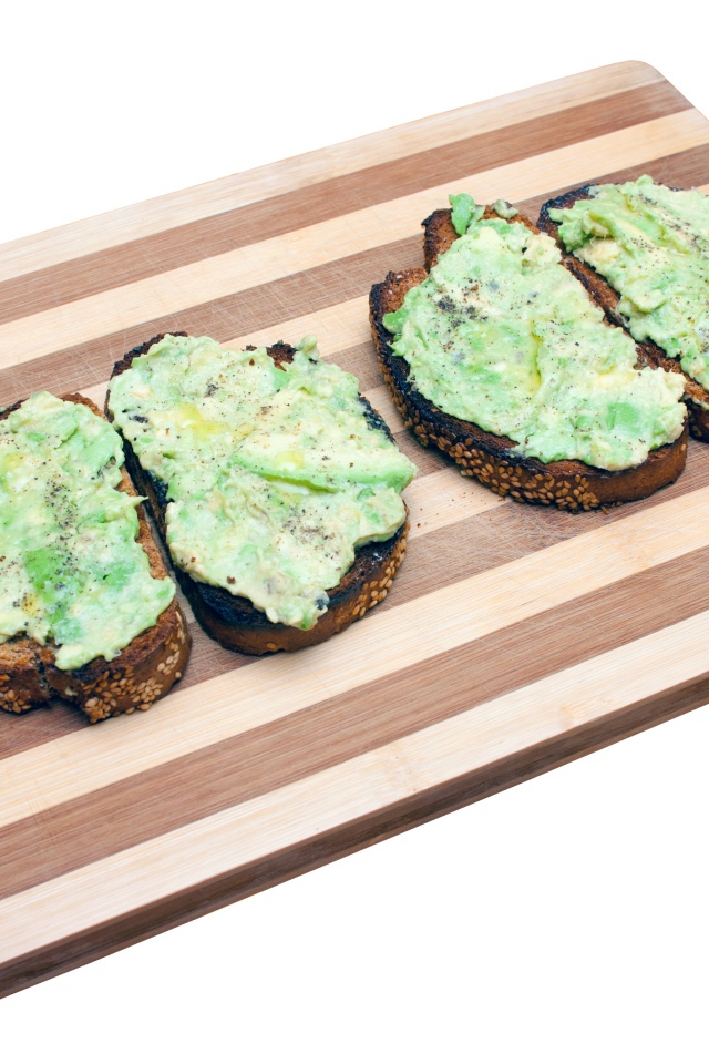 Бутерброды с черного хлеба на доске на белом фоне