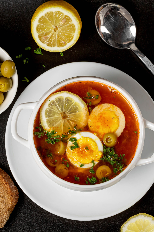 Солянка на столе  с хлебом и оливками 