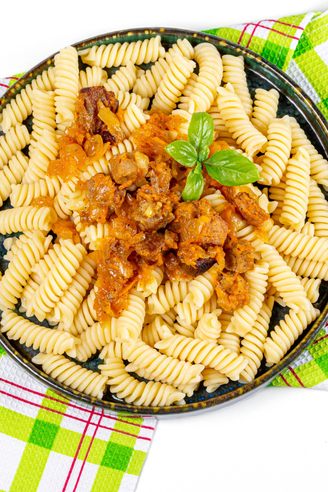 Макароны спираль с мясом на тарелке