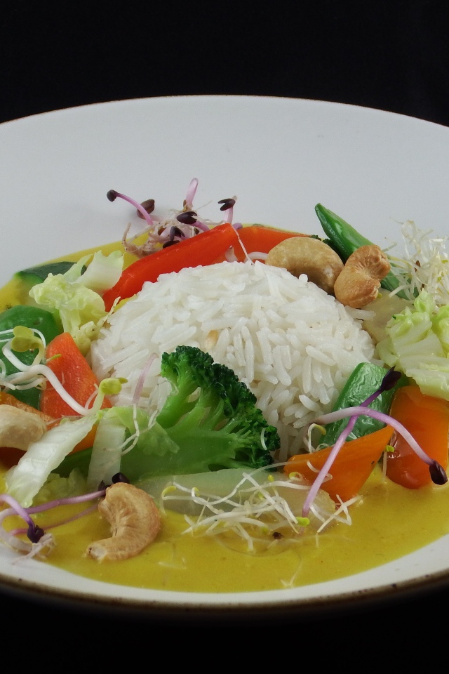 Вареный рис с овощами в большой белой тарелке