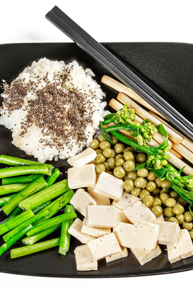 Овощи, сыр и рис на тарелке с палочками