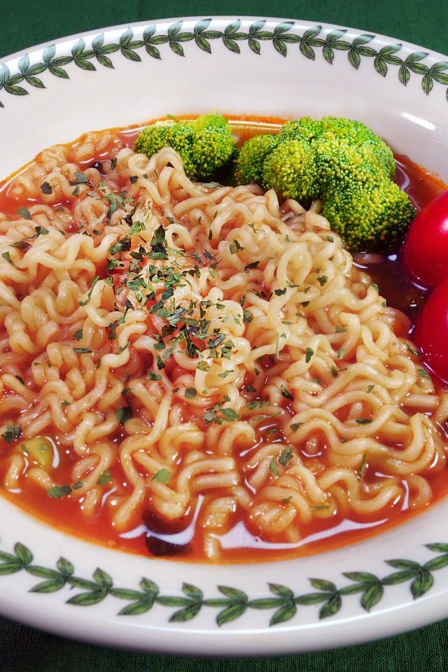 Вермишель с соусом в тарелке с помидорами