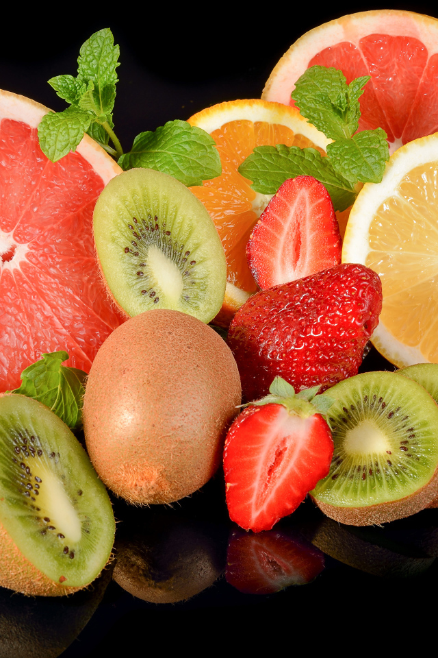 Цитрусовые фрукты с клубникой на черном фоне