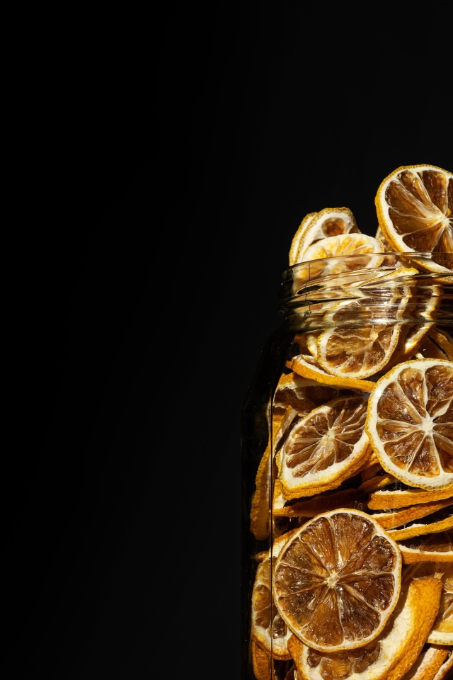 Сушеные лимоны в банке на черном фоне