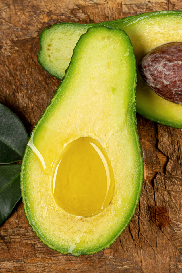Зеленое авокадо на деревянном столе