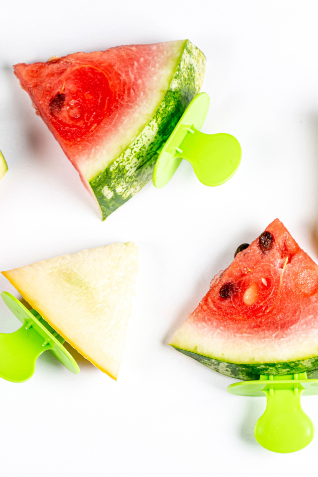 Кусочки арбуза и дыни на палочке на белом фоне 