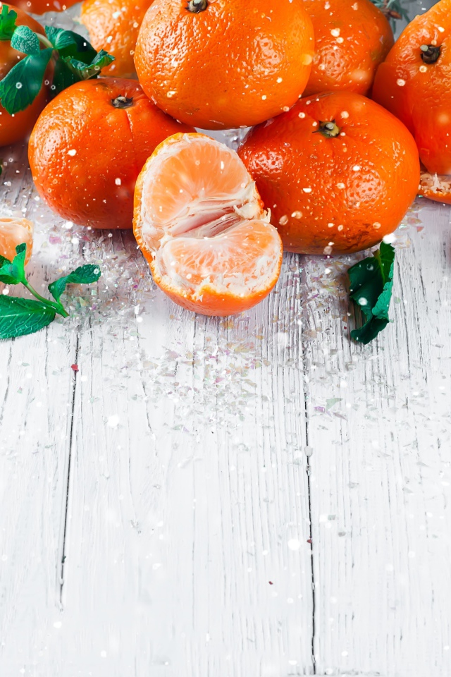 Спелые сочные мандарины с мятой на столе