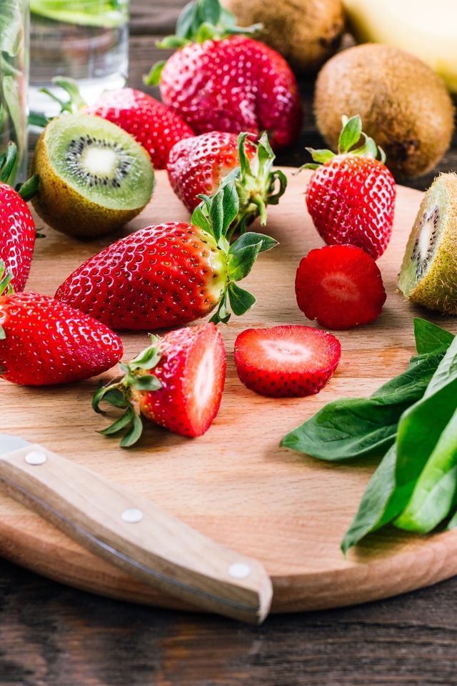 Нарезанная клубника и киви на деревянной доске 