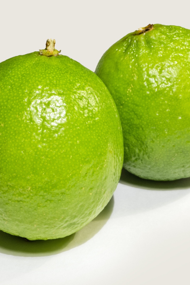 Два больших зеленых лайма на столе