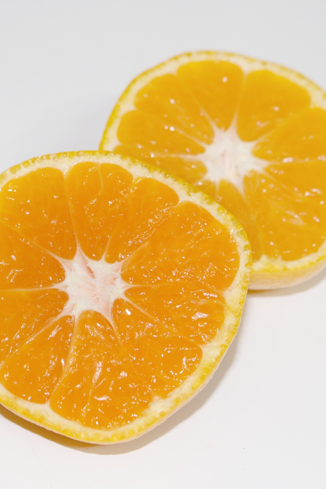 Два кружочка мандарина на сером столе 