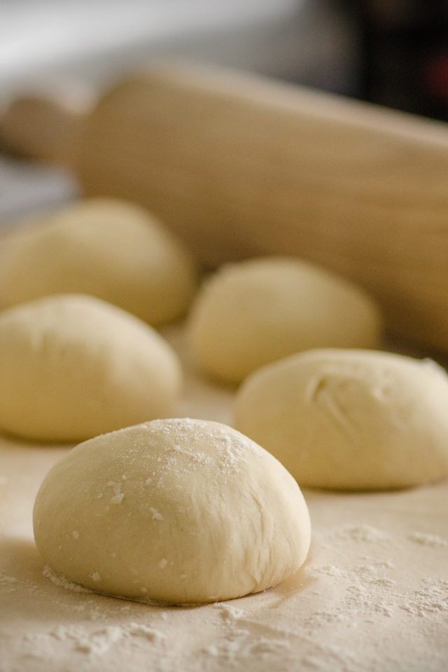 Тесто для булочек и скалка на столе 