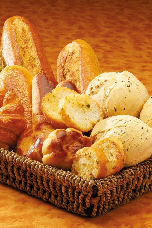 Вкусная свежая выпечка в корзине на столе 