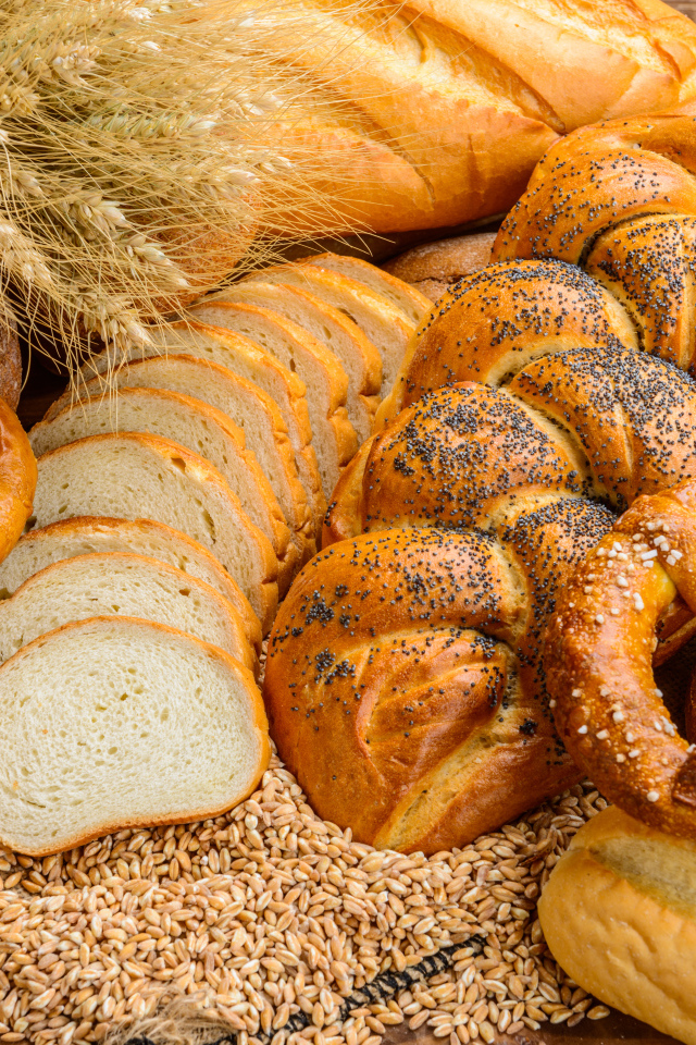 Свежая выпечка на столе с колосьями и зернами пшеницы 