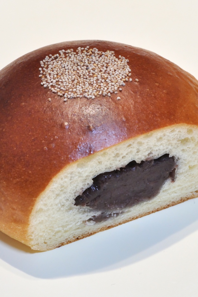 Свежая румяная булочка с вареньем на белом фоне