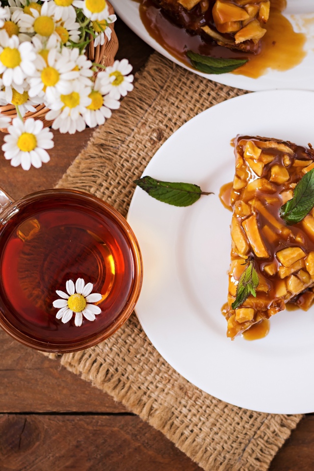 Кружка ромашкового чая на столе с куском пирога