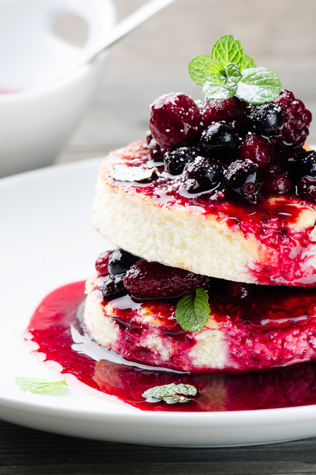 Аппетитные сырники с ягодами на белой тарелке 