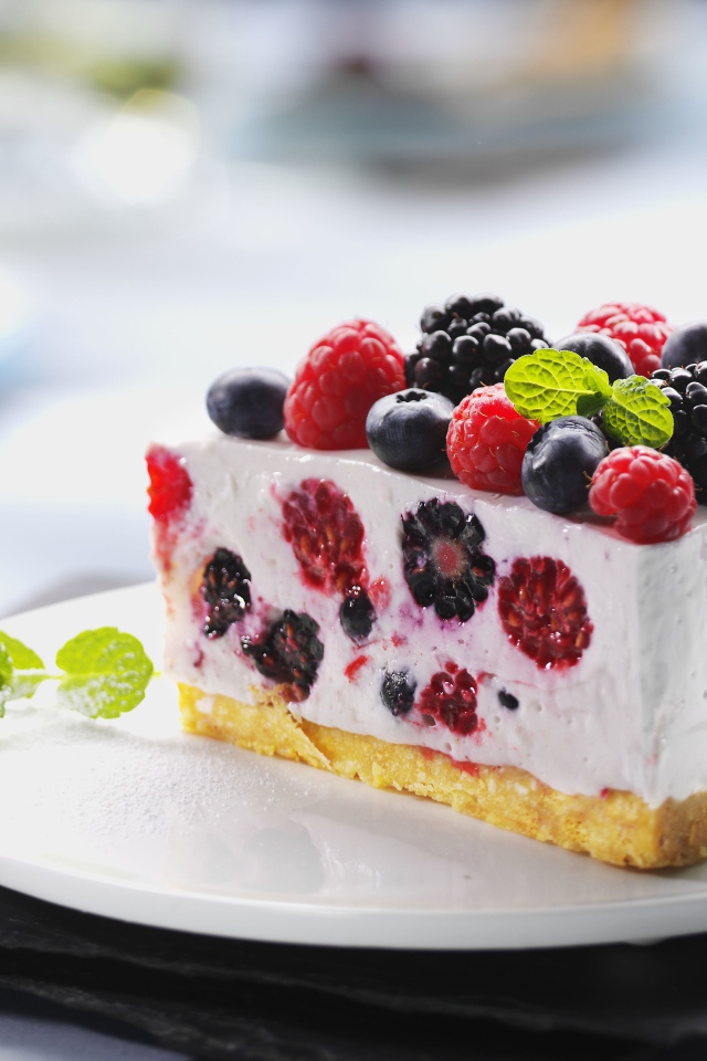 Аппетитный торт-суфле с ягодами на белой тарелке