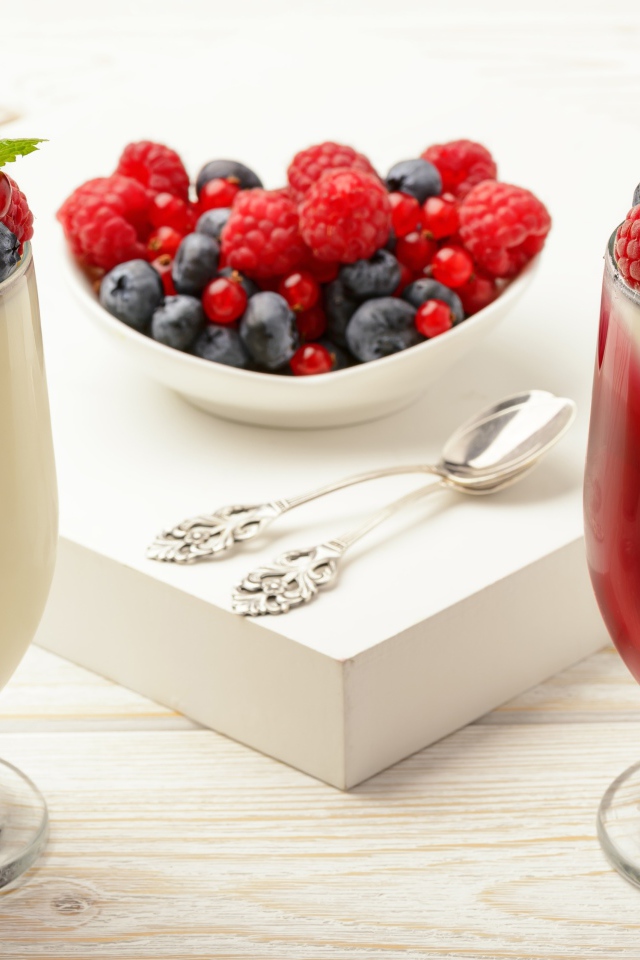 Двухцветный десерт с ягодами на столе 