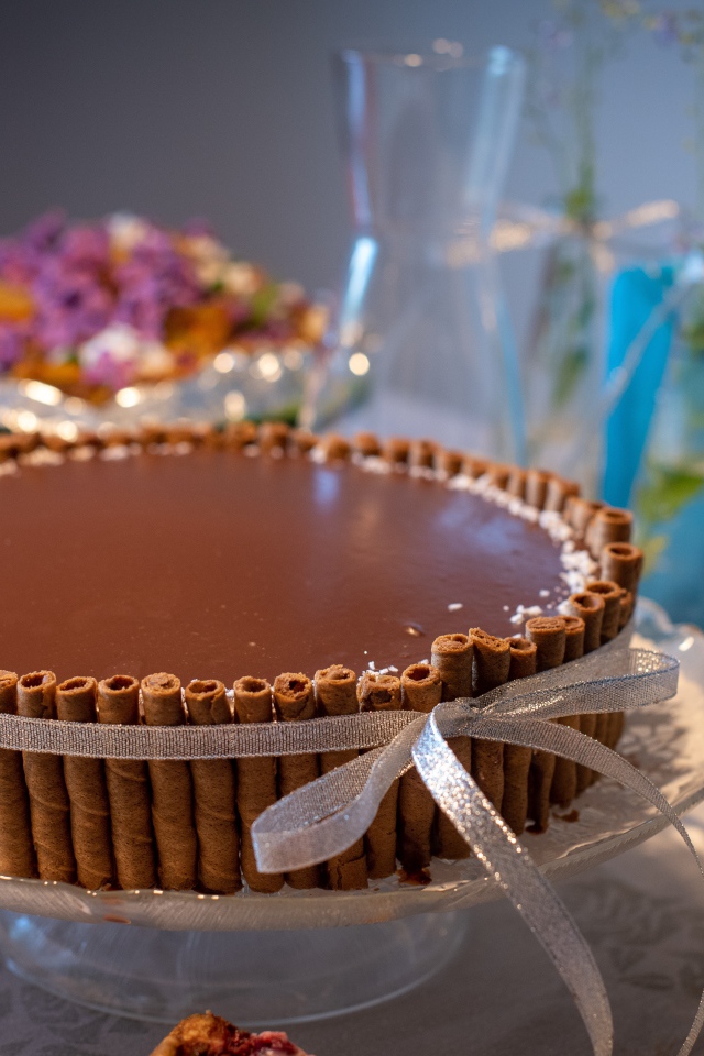 Большой шоколадный торт с трубочками на столе