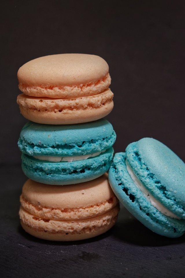 Голубой и коричневый десерт макарун на сером фоне