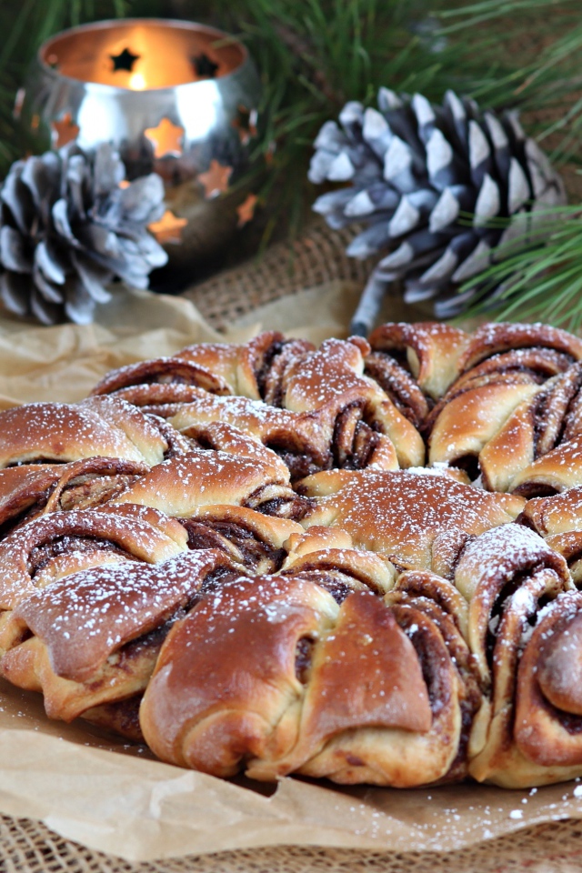 Сдобный венок с вареньем на столе с шишками