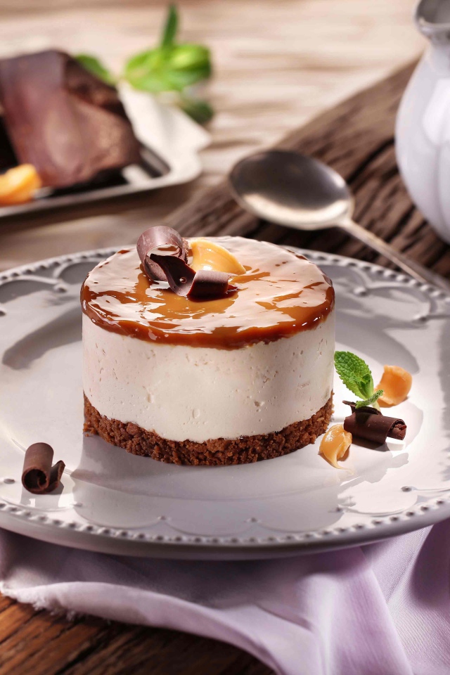 Пирожное на большой круглой тарелке на столе с шоколадом