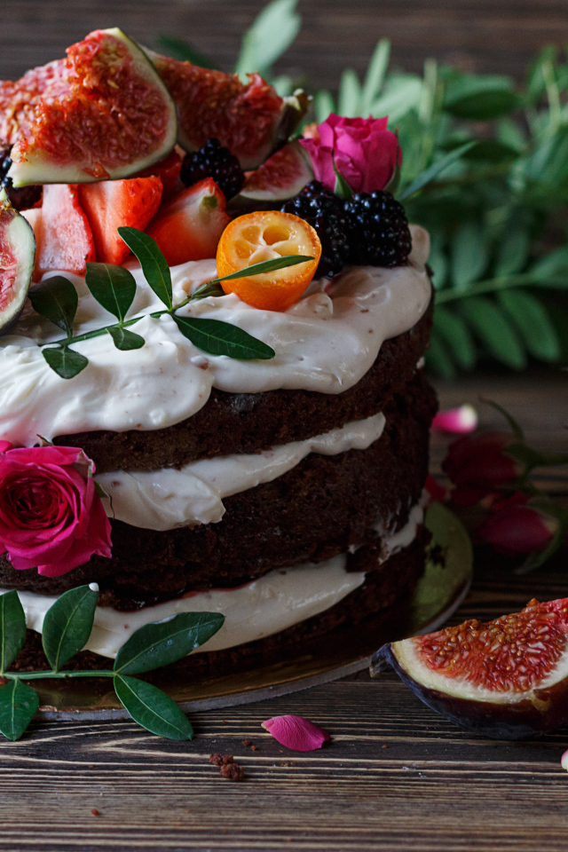 Торт с шоколадными коржами и сливочным кремом украшен ягодами